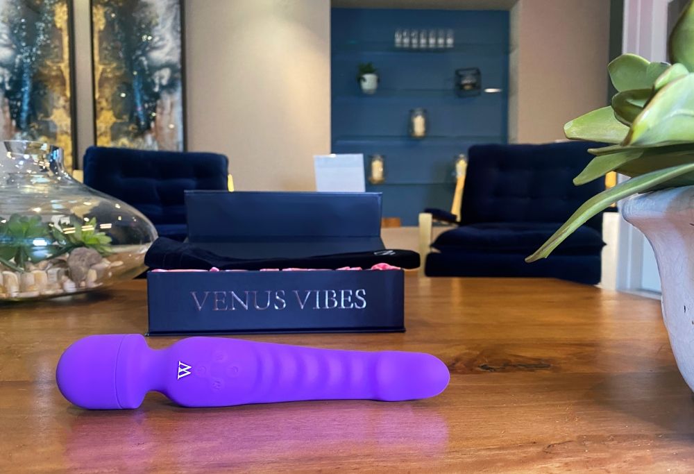 Venus flexible wand vibrator in purple with box on a wooden table, showcasing its design and features.