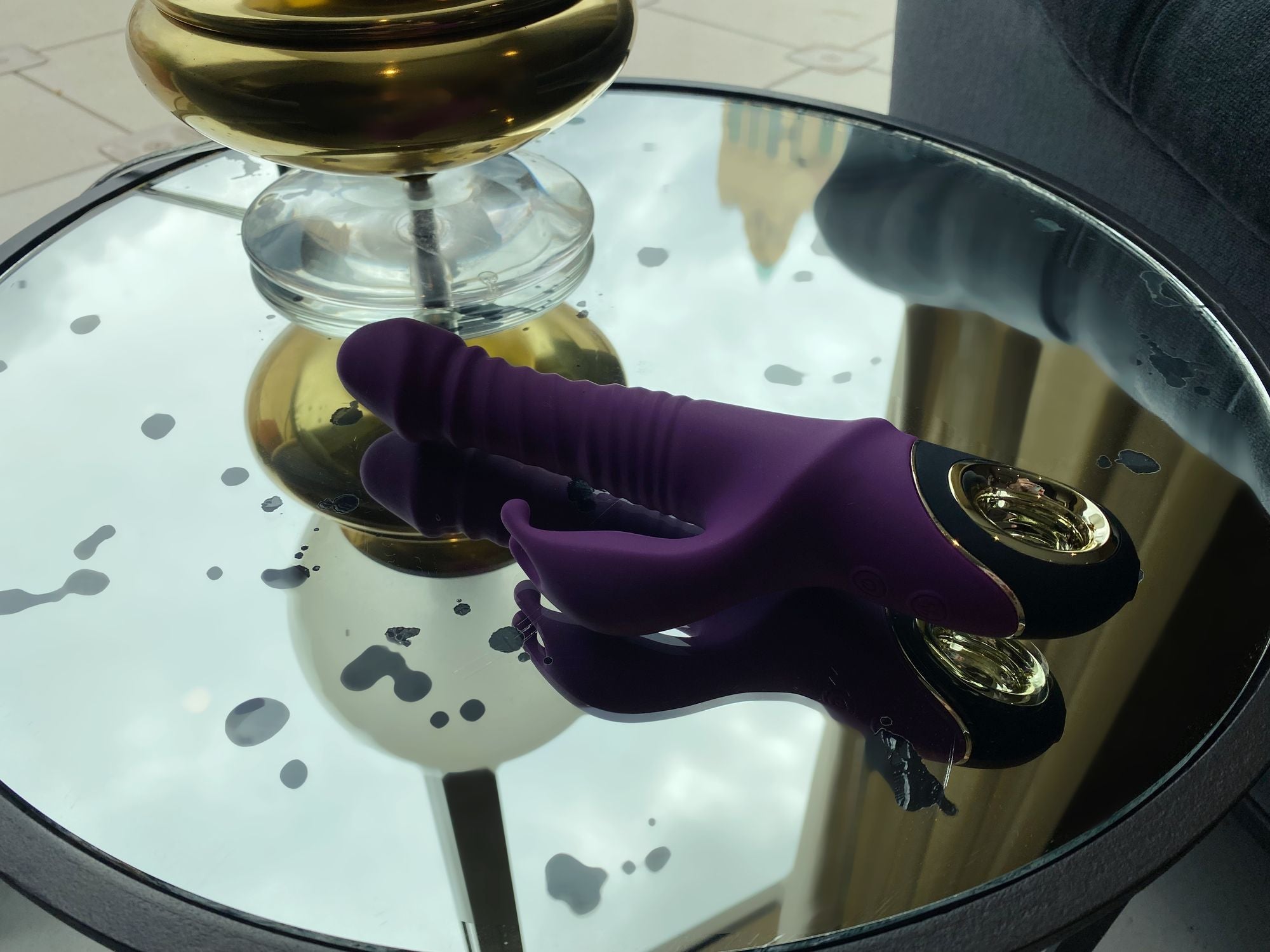 thrusting vibrator for pleasure on reflective surface, showcasing its elegant design and features.